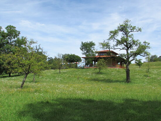 Das Kloster liegt auf einem Hügel umgeben von Wiesen und dem Blick auf die umliegenden Berge.