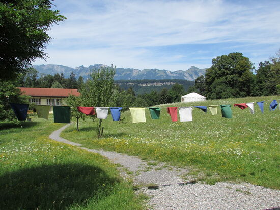 Bunte Gebetsfahnen im Wind tragen die Mandalas, die auf ihnen geschrieben sind, in die Welt hinaus.
