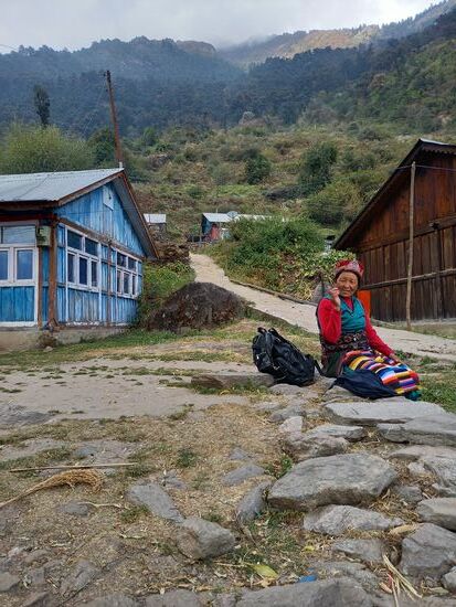 Auch diese Frau legt eine Rast ein. Sie trägt traditionelle Tamang Kleidung,  so wie es gerade von den älteren Frauen noch viel getragen wird.