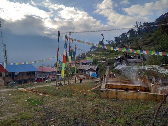 Der Ort ist mit unzähligen bunten Gebetsfahnen geschmückt.  Rechts im Foto dampft in drei Becken heißes Wasser - unsere Dusche. Hier gibt es heiße Quellen und diese Becken dienen tatsächlich der Körperhygiene. Da wartet wieder ein Abenteuer auf uns  Passang will mit uns im Schutze der Dunkelheit duschen gehen  