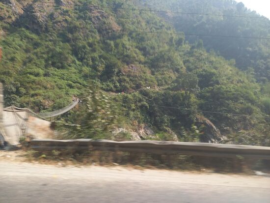 Links im Bild eine der vielen Hängebrücken die über den Fluss führen.