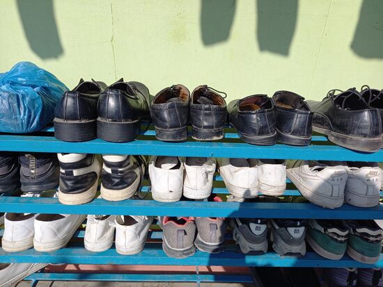 Jedes Kind hat zwei Paar Schuhe für die Schule. Ein paar schwarze und ein paar weiße Turnschuhe.  Die meisten Schuhe sehen total mitgenommen aus.