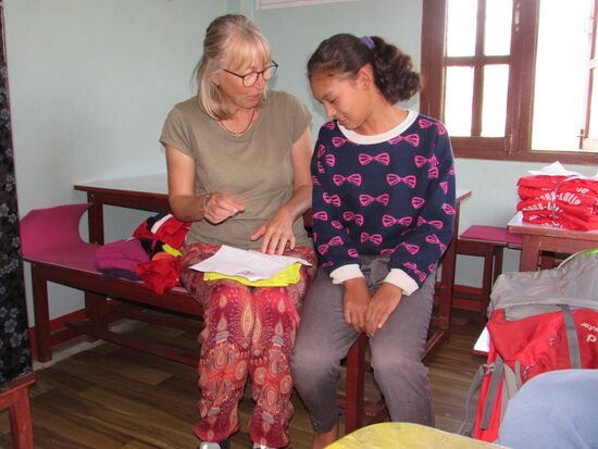 Tenzin hat einen Brief, ein T-Shirt und Haargummis von ihrem Paten erhalten.