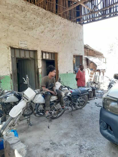 Im roten T-Shirt der Mechaniker und auf der Crossmaschine sitzt sein Sohn.