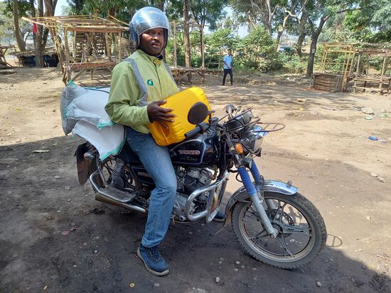 Mit dem Motorrad wird die Ware ins Afroplan gebracht.