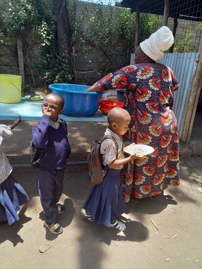 Die Köchin verteilt das Essen.