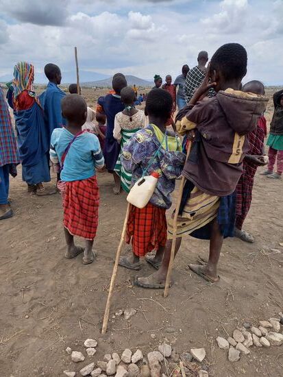 Einige Kinder haben Plastikbehälter dabei, in denen sie etwas Wasser dabei haben.