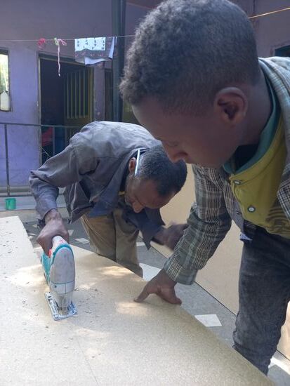 Happy bestellt einen Mann mit Stichsäge ein. Er schneidet die Platten zu.