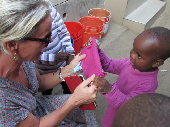 Der Kleine freut sich über das neue T-Shirt und die kleine Tasche.