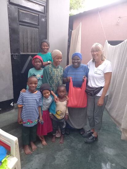 Er lebt bei seiner Großmutter in einer Großfamilie. Die Großmutter strahlt  als sie die Lebensmittel bekommt.