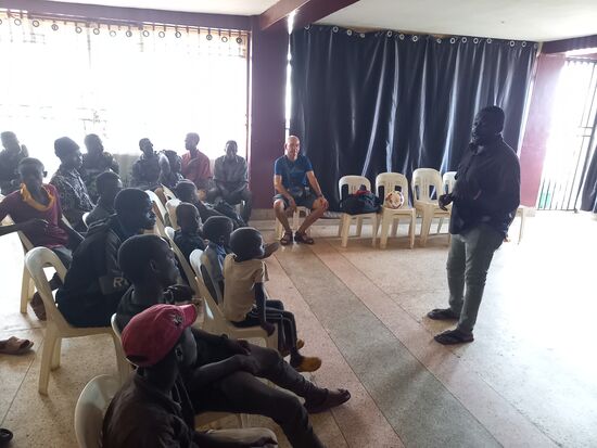 Zusammen mit den Jungs gehen wir in einen Raum den die Kirche für die soziale Arbeit zur Verfügung stellt. Paul stellt uns vor und dann spreche auch ich ein paar Worte zu ihnen, ehe wir die Trikots verteilen.