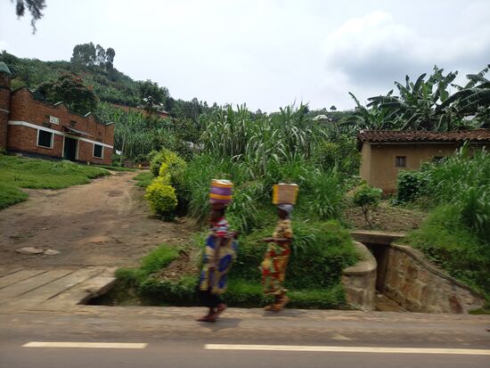 An den Straßenrändern sind viele Menschen zu Fuß unterwegs.
