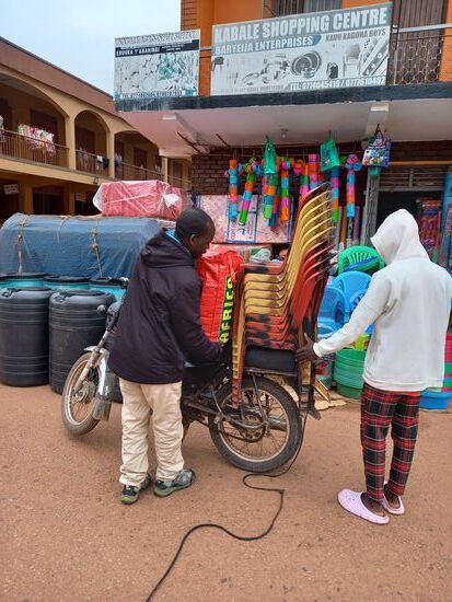 Ich beobachte wie dieses Motorrad mit zig Stühlen und einem großen Sack bepackt wird.