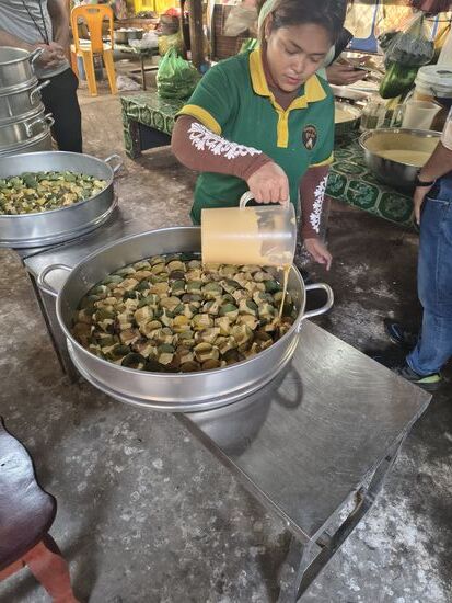 Palmmehlkuchen. Aus Palmmehl, Zucker und kokosmilch wird ein dünner Teig bereitet, in Förmchen aus Bananenblättern gefüllt und in der Mitte mit einem Klecks Kokoscreme versehen