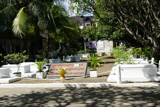 Die weißen Steinsärge symbolisieren die letzten 14 in S21 getötenen Menschen, die Frangipani gibt es in fast allen Tempeln und standen schon da als es eine Schule war.