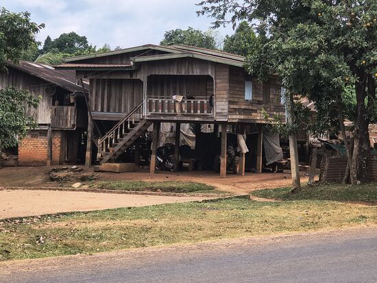 Typisches  Holzhaus am Land. In der Trockenzeit spielt sich das Leben unterm Haus statt, in der Regenzeit kann das Wasser durchrauschen