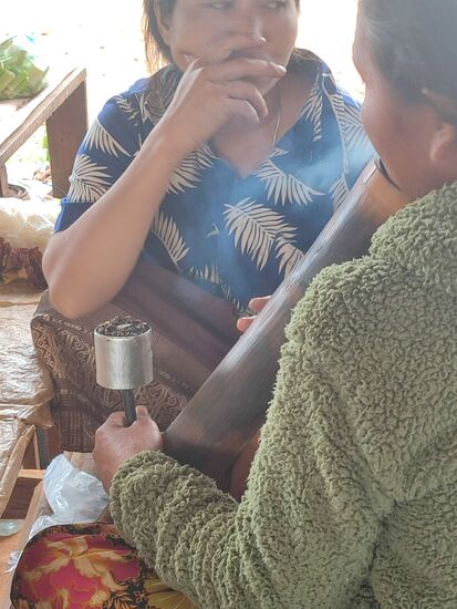 Die Frauen unterhalten sich und rauchen zusammen Pfeife