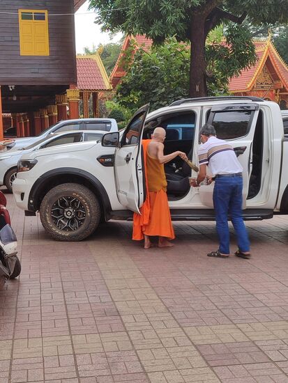 Autosegnung in Simuang, der alte Mönch besprüht das Auto innen und außen mit geweihtem Wasser und betätigt ausgiebig die Hupe. Damit sind das Auto und die Insassen geschützt vor allem Bösen. Wenn man sich ne Zeitlang auf dem Gelände aufhält hört man immer wieder Autos hupen, dann weiß man der TÜV auf laotisch ist erfolgreich durchlaufen