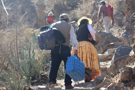 Die beiden wandern zu den Ruinen hoch und das Bild ist sehr typisch für peruanische Reisen und Ausflüge, man hat immer jede Menge Taschen und Tüten dabei, keine Ahnung was sie da immer mitnehmen.