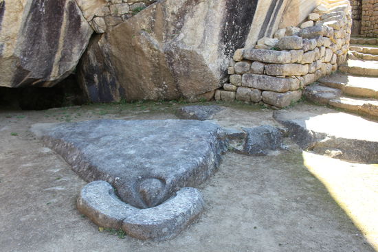 Der Tempel des Kondor mit einem  stilisierten Kondorkopf mit Schnabel auf dem Boden. Der tiefe Hohlraum unter dem gewaltigen stein im Hintergrund soll als Gefängnis gedient haben.