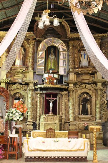 Der prächtige geschnitzte Holzaltar nimmt die ganze Frontseite der Kirche ein.