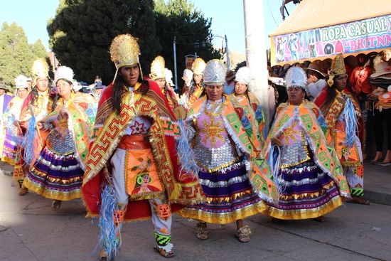 Danach kommen Tänzer in farbenfrohen und glitzernden Kostümen