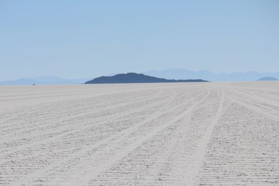 Balberto forderte uns nach dem fotografieren zu einer kleinen 10-minütigen Wanderung zu der Felsinsel auf, er wollte noch das Auto einräumen und uns dann dort treffen. Die Insel erschien uns sehr nah und wir liefen los, nach 20 Minuten war die Insel nicht wirklich nähergekommen und Balberto lud uns wieder ins Auto. Es ist unglaublich wie man sich hier auf dieser weißen Fläche in den Entfernungen verschätzt.