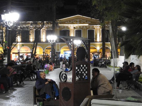 Auch am späten Abend ist der Hauptplatz bevölkert und eine Schuhputzerin wartet auf Kunden