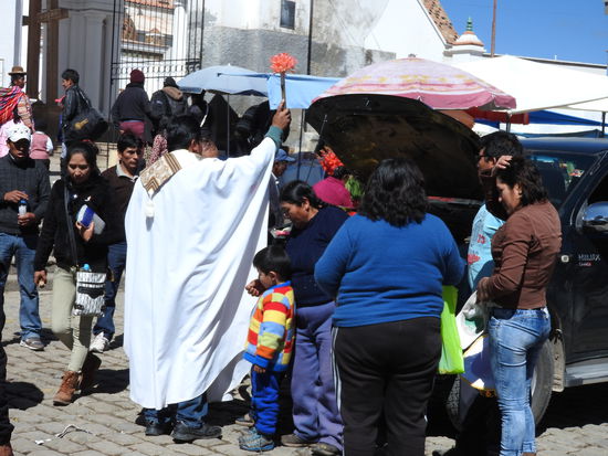 Und dann kommt der Priester, betet mit jedem Autobesitzer und dessen Familie, segnet die Menschen und dann wird der Motorraum und das Auto innen und außen mit dem Weiwasserwedel besprüht und mit Kreuzen gesegnet gesegnet. Die Autos stehen hier mehrere Tage in langen Schlangen vor der Kirche und der Priester hat soviel zu tun dass er  das Weihwasser im großen Eimer mit sich trägt.
