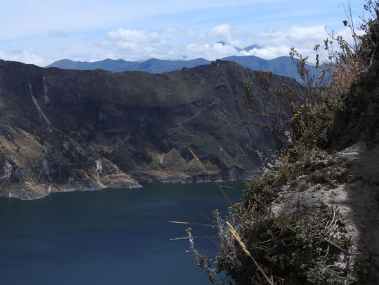 Im Hintergrund spitzen die beiden Gipfel des inaktiven Vulkans Iliniza  aus den Wolken zu dessen Nationalpark die Lagune gehört.