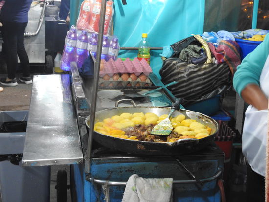 An etlichen abends  aufgebauten Essensständen gibt es lokale Spezialitäten wie Fleisch und Würstchen auf Spießen dazu Llapingachos  (gewürzter Kartoffelbrei zu Pflanzerln geformt und angebraten).
Llapingachos  gabs auch bei meiner Großmutter, da hieß es "Geditschde-Gedatschde und sie wurden mit Apfelbrei gegessen.