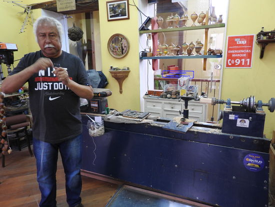 Dieser findige Drechsler  stellt große Holzfadenkreisel her und da der Absatzmarkt dafür klein ist bietet er sie auch als  Weihnachtsschmuck an. Im Hintergrund sieht man einige der  fertigen bemalten Kreisel