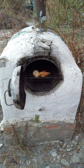 In diesem Ofen bereitet er uns leckere gebackene Camote (Süsskartoffeln)