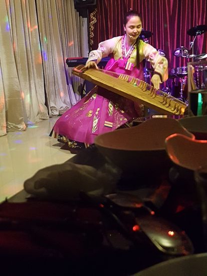 Die Kellnerin hatte vorher in China gearbeitet und sprach sehr gut Chinesich. Zwischen dem Essen gab es eine Einlage und das urtuemliche Instrument schmiss einen unbeschreiblichen Sound. Bei uns waere das der Zittermanni....
Interessant waren natuerlich einige Infos ueber Nordkorea. Als ich ein Foto von meinen Sohn mit der nordkoreanischen Flagge in der Hand vom USA-Urlaub gezeigt habe, war das Eis gebrochen!