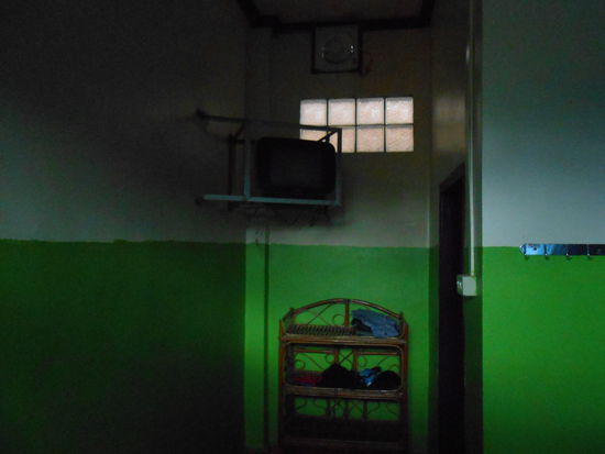 Zimmer in Paksong ohne Fenster, oben links der Fernseher