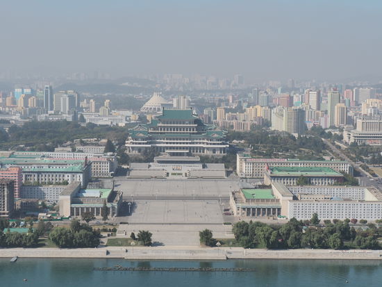 Blick vom Juche-Turm auf den Kim-Il-Sung-Platz und den großen Studienpalast des Volkes. Direkt hinter dem Palast befindet sich eine Eissporthalle (kuppelförmiges Gebäude).