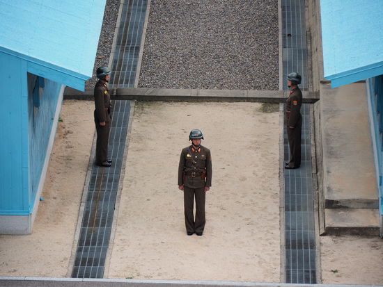 Nordkoreanische Soldaten an der DMZ - Der mittig der Barracken gelegene Betonstreifen markiert den Grenzverlauf