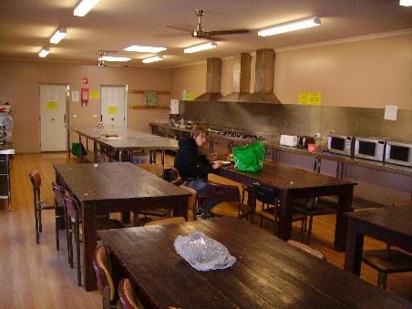 Die Kueche & Tim. Hier draengeln sich morgens und abends viele hungrige Leute rein. Die gruene Tasche auf dem Tisch hat hier fast jeder. In die packt man seine Essenssachen und stellt sie hinten in eins der Kuehlraeume (Tueren hinten links und rechts)