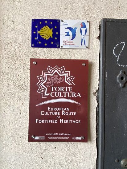 Die gelbe Pilgermuschel auf blauem Grund bei der Zitadelle als Wegzeichen des Rheinhessischen Jakobsweges sowie der Via Regia.