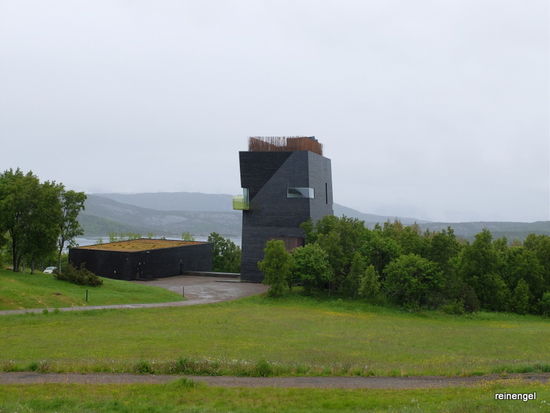 Wir passieren die Gedenkstätte an den norwegischen Literaturnobelpreisträger Knut Hamsun. "Im Jahr 2009 wurde das Gebäude mit einer großen Eröffnungsfeier anlässlich des 150. Jahrestags der Geburt Hamsuns fertiggestellt und durch die Kronprinzessin Mette-Marit eröffnet. Nach Fertigstellung der Ausstellungs- und Inneneinrichtung wurde das Zentrum dann am 13. Juni 2010 für das Publikum geöffnet. Der Bau wurde 2010 mit dem „International Architecture Award“ ausgezeichnet, 2011 mit dem norwegischen Statens byggeskikkpris." (de.wikipedia.org/wiki/Hamsun-Zentrum)
