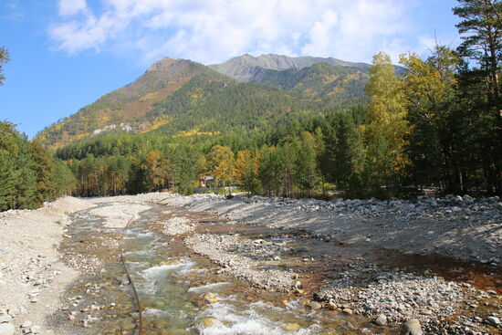 Herbst in Sibirien. Im Flussbett sieht man eine Wasserleitung liegen