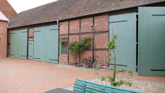 Hinter dem rechten großen Scheunentor stehen die Räder