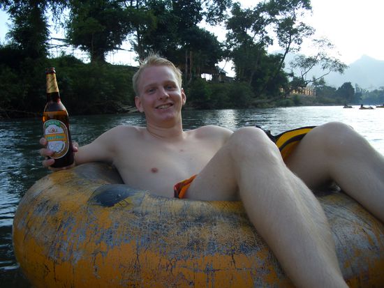 Marco treibt den Fluss hinunter und geniesst ein LaoBier