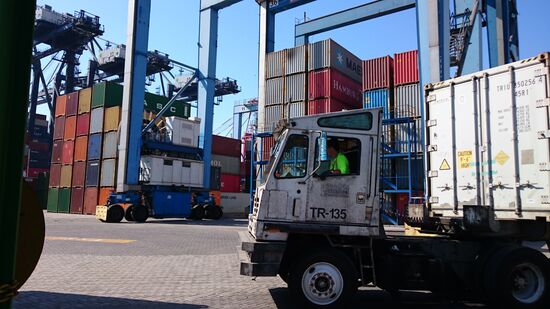 Von unten sind die Container und Lastwagen riesig