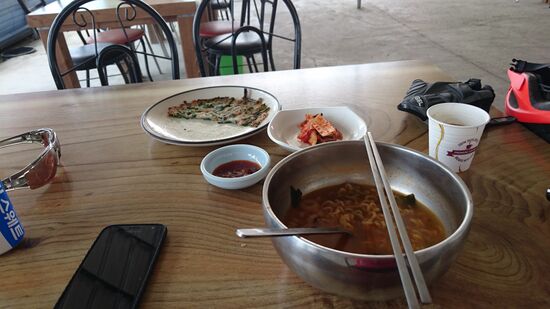 Koreanisches Frühstück. Nach der Nacht im Zelt bin ich froh in einer landwirtschaftlichen Halle ein Restaurant zu entdecken.