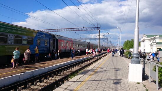 Längerer Halt. Die Zugbegleiterin ruft die Fahrgäste rechtzeitig in den Zug, bevor er weiterfährt