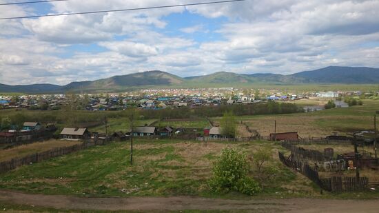 Der Zug fährt an zahlreichen Dörfern vorbei, die hauptsächlich aus Holzhäusern bestehen