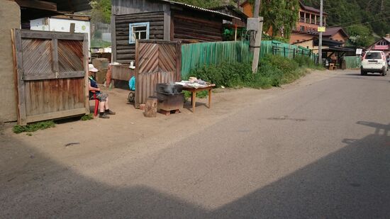 Vor den Türen wird Fisch geräuchert