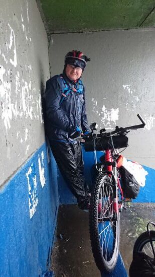 In der Bushaltestelle suchen wir Schutz vor dem Starkregen