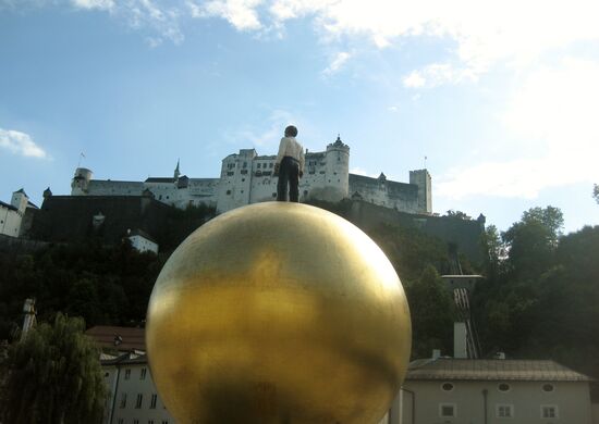 "Mensch auf einer goldenen Kugel"